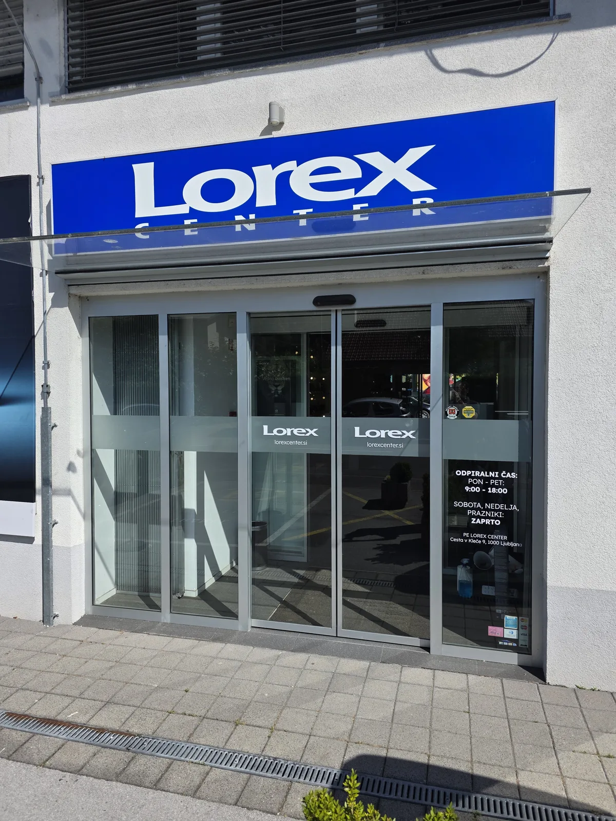 Lorex Center, zunanja tabla in steklena vrata z označbami in delovnim časom