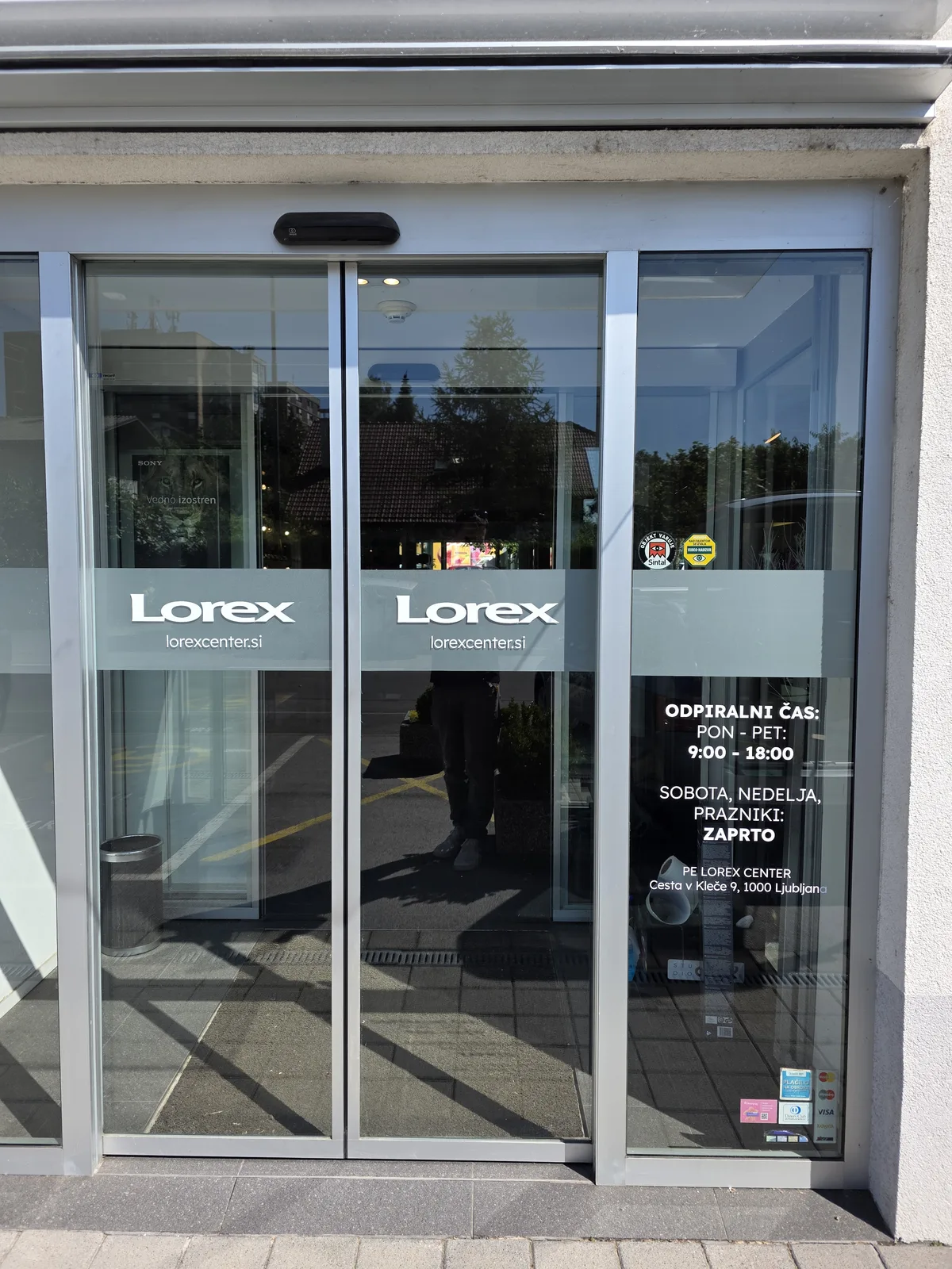 Lorex Center, detajl rezane folije in delovnega časa na steklu