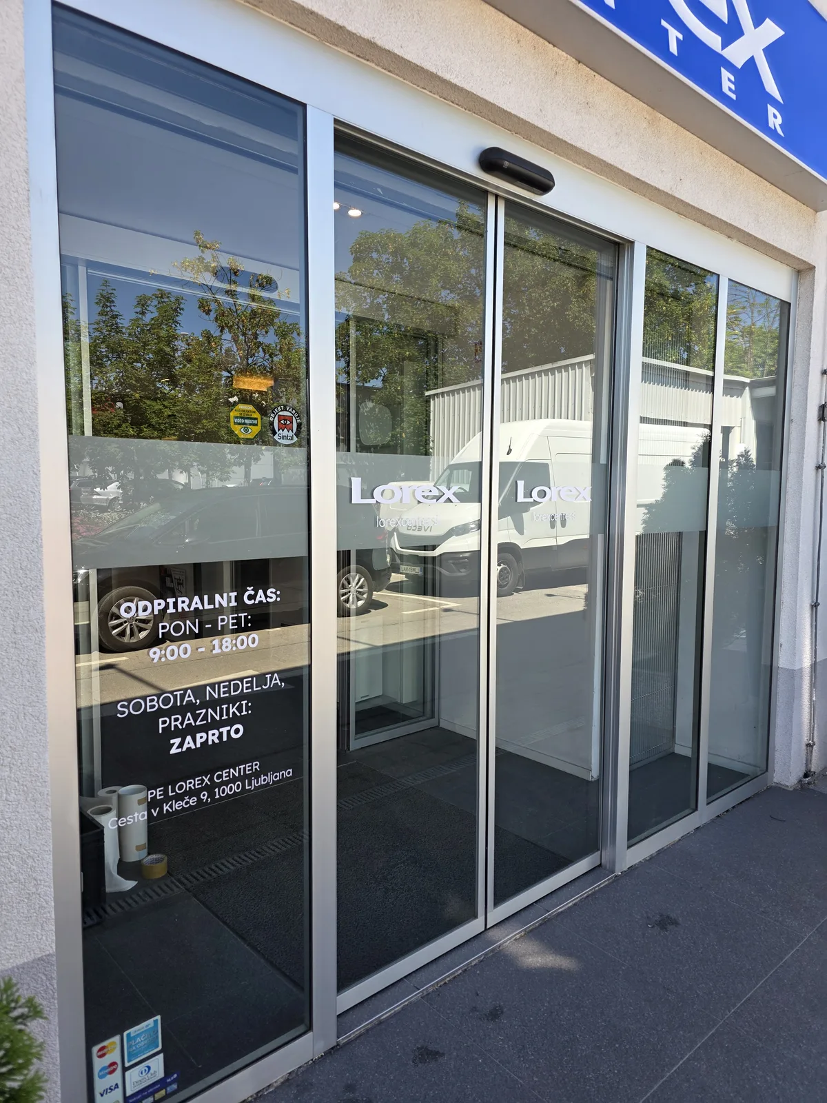 Lorex Center, detajl rezanega logotipa in delovnega časa na drsnih vratih