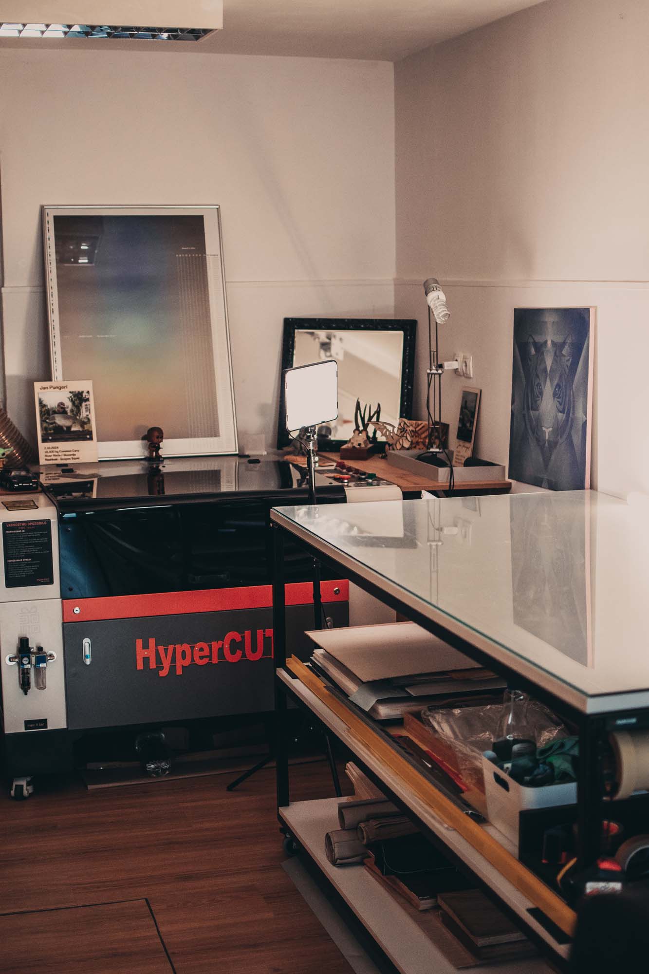 Produkcijski prostor studia Dono — laserski rezalnik, materiali in uokvirjeni izdelki